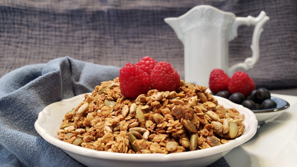 A bowl of granola with berries in a bowl on a napkin