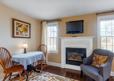 Beach Blossom Fireplace Bed with Chairs | Brewster By the Sea Cape Cod B&B | Brewster, MA