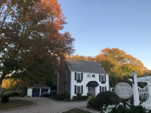 House front with white gate and picket fence, adding a touch of elegance to the property.